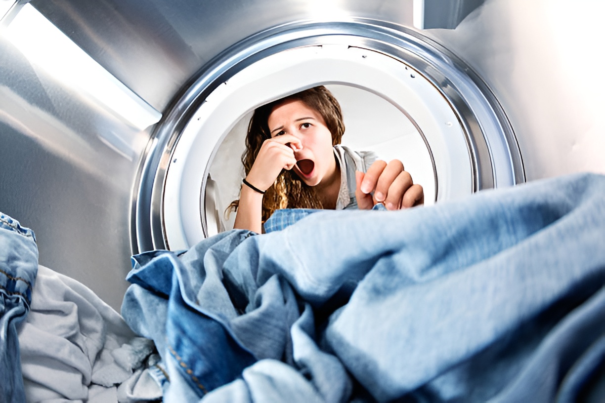 woman pinching her nose while peeking at a washing machine